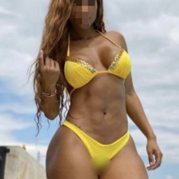 Emyli stehend im gelben Bikini, zeigt ihren durchtrainierten Körper